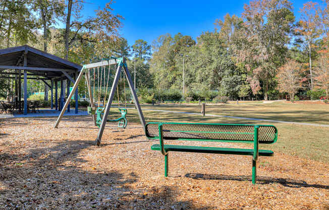 a swing set and a bench in a park