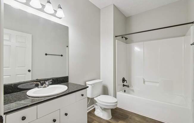 A white bathroom with a sink, toilet, and bathtub.