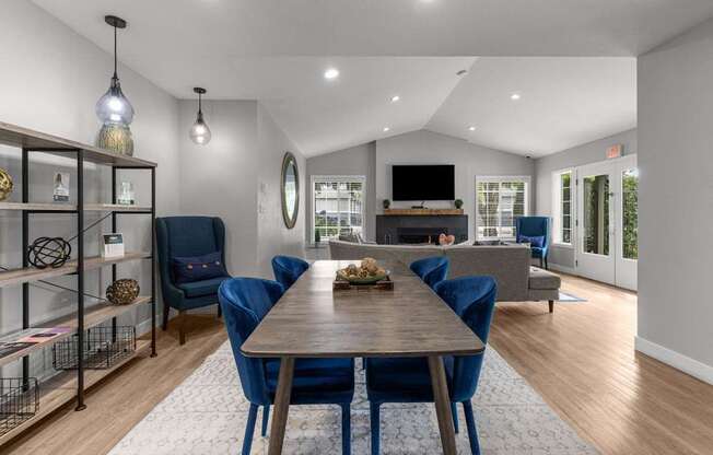 a living room with a wooden table and blue chairs