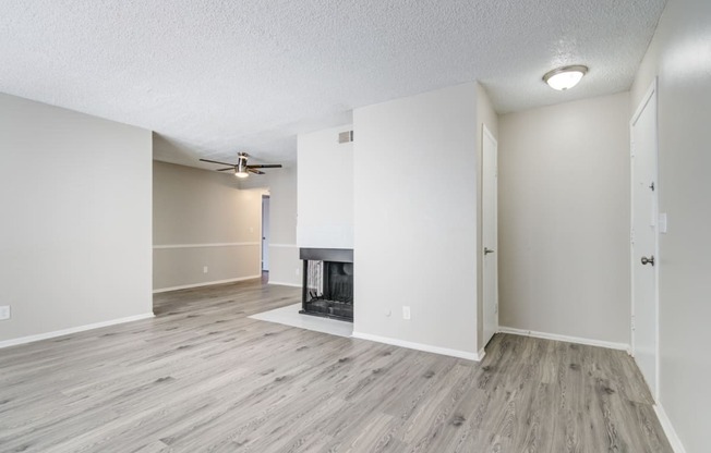 an empty living room with a fireplace and white walls