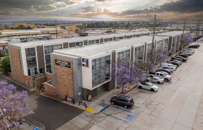 A parking lot with cars and a building with a sign that says "CITY HALL".
