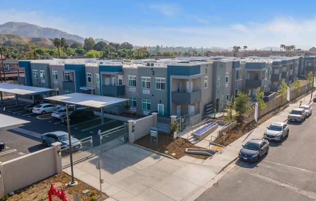 a row of apartment buildings with cars parked in front of them at Loma Villas Apartments, San Bernardino