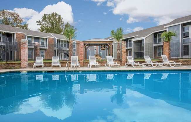 a swimming pool in front of a row of apartment buildings