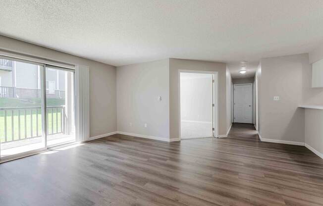 A room with wooden flooring and white walls.