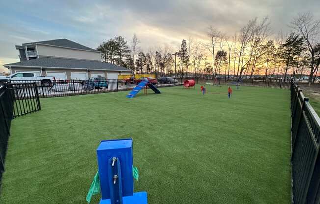 Dog park with a fence with obstacles at Aurora apartments