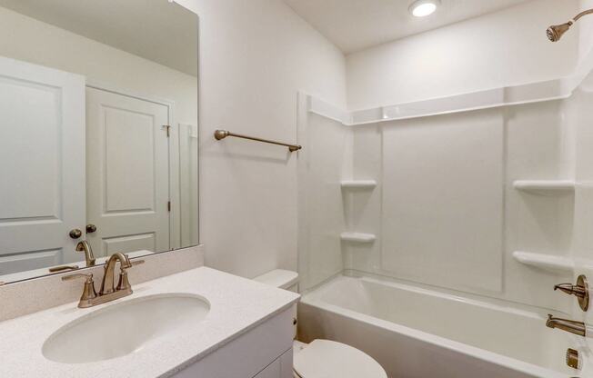 a bathroom with a sink and a tub and a mirror