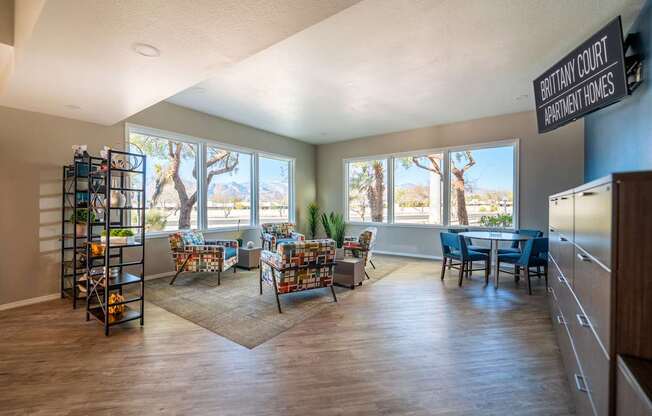 A living room with a couch, chairs, and a dining table with a view of the outdoors.