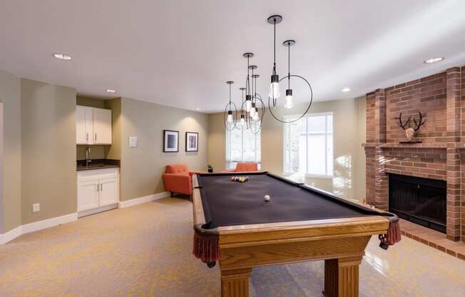 a game room with a pool table and a fireplace