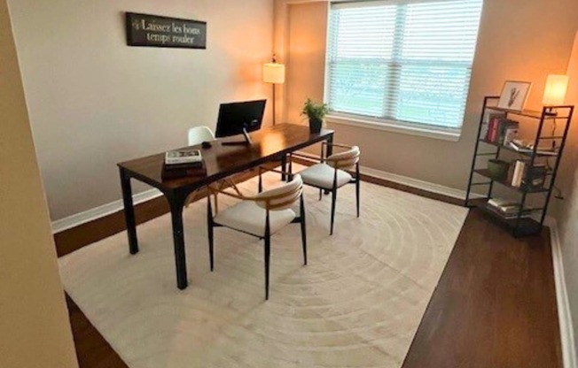 A room with a desk and a chair in it.