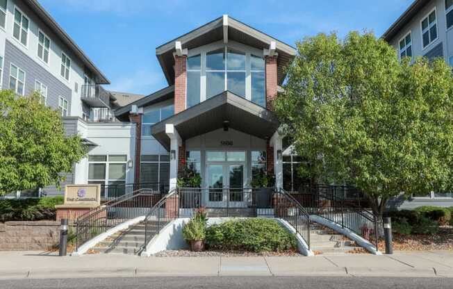 A modern building with a glass entrance and a brick chimney.