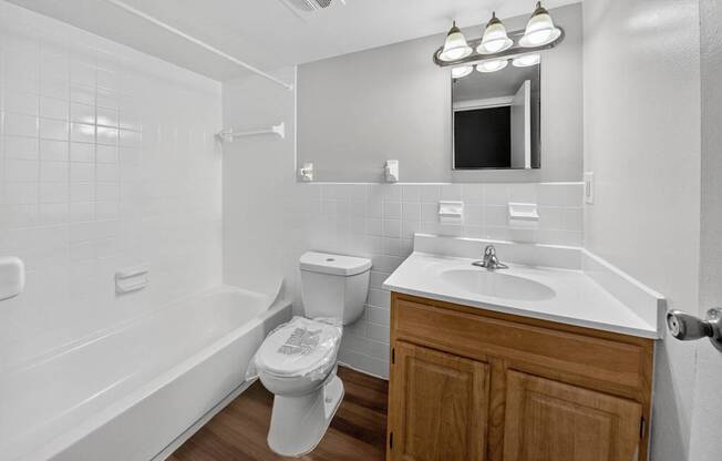 A white bathroom with a toilet, sink, and bathtub.