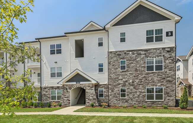 an apartment building with a stone and white facade