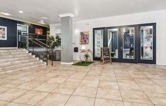 A spacious lobby with a staircase and a sign that says "SUMMER".