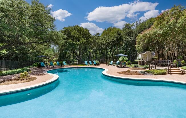 The sparkling resort-style pool is set against a backdrop of shade trees and tranquil seating—your go-to for relaxing afternoons.