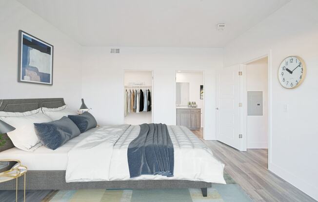 a bedroom with white walls and a large bed with blue and white bedding