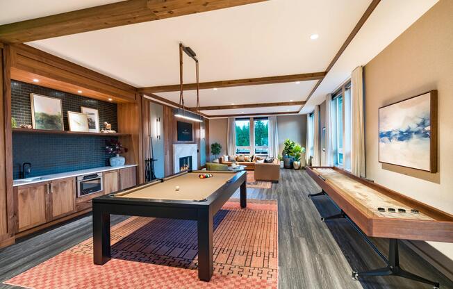 The game room at Modera Bridle Trails pairs a cozy fireplace with warm wood paneling for relaxed evenings and friendly competition.