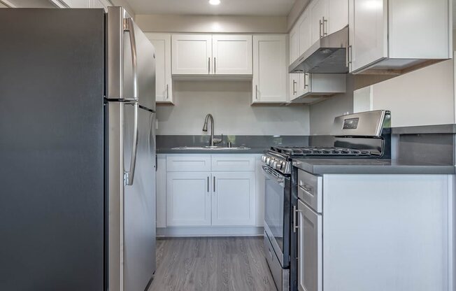 a kitchen with stainless steel appliances and white cabinets