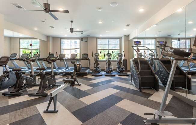 a gym with cardio machines and weights on a checkered floor