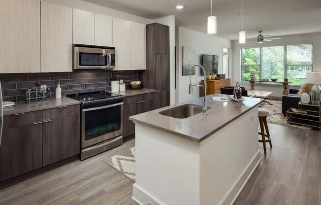 A modern kitchen with a white island and dark wood cabinets.