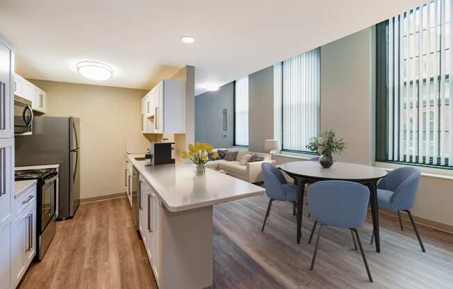 a living room and kitchen with a table and chairs and a refrigerator at Royal Worcester Apartments, Massachusetts, 01610