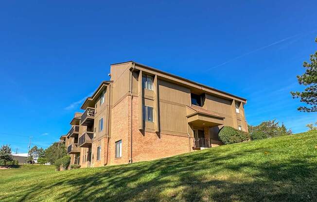 A large brick building with a green lawn in front.
