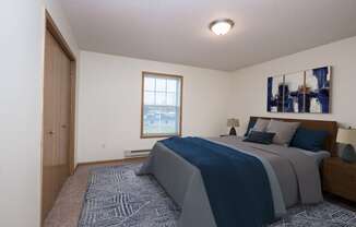 a bedroom with a bed and a door to a bathroom. Fargo, ND Stonebridge Apartments