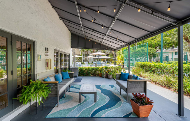 a patio with couches and tables and windows