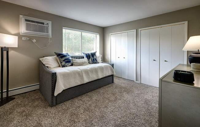 a bedroom with a bed and an air conditioner and a closet