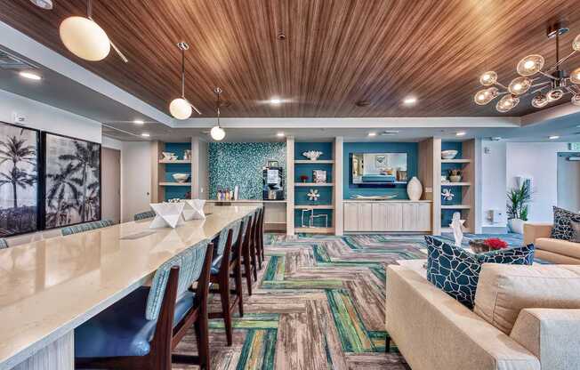 A long wooden table is surrounded by chairs in a room with a wooden ceiling.