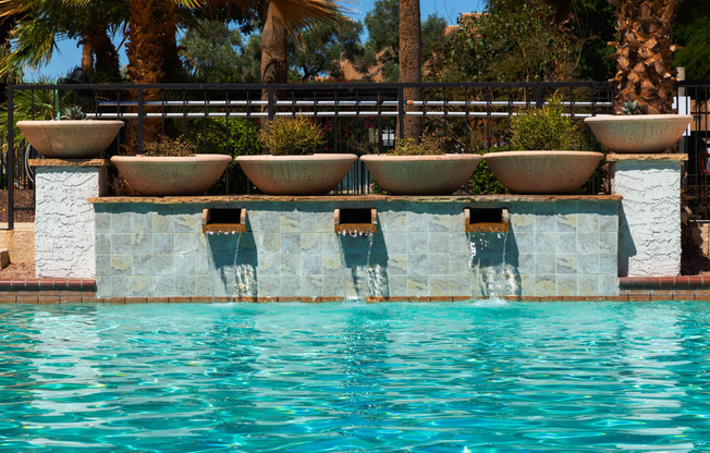 a swimming pool with a row of flower pots on the side