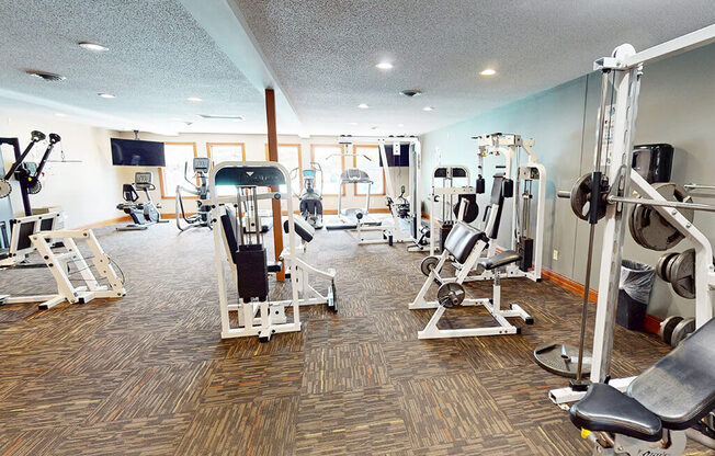A gym with a variety of equipment including weights and machines.