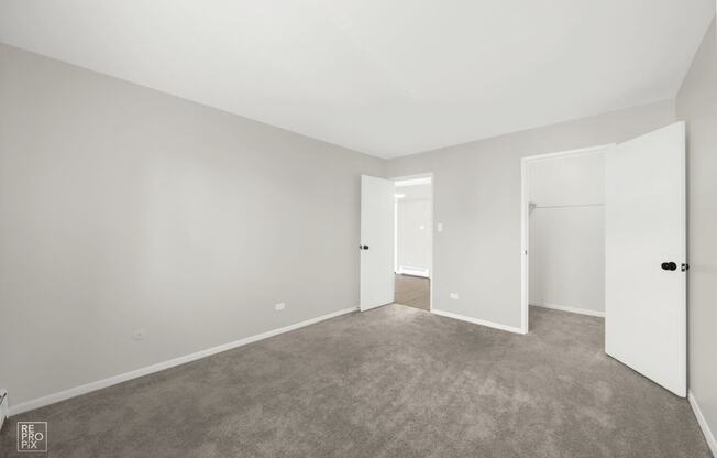 a bedroom with a carpeted floor and white walls