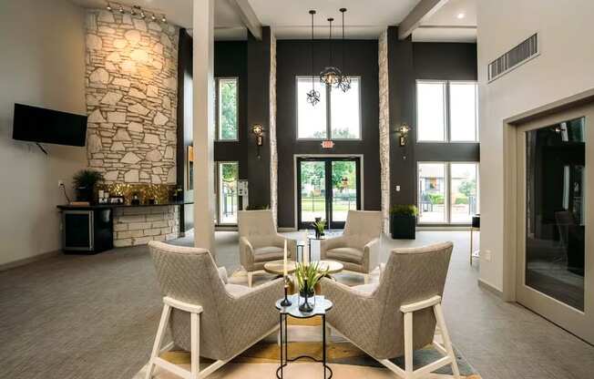 a living room with couches and chairs and a stone fireplace