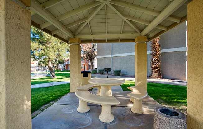 A white pedestal sink is in the middle of a concrete patio.