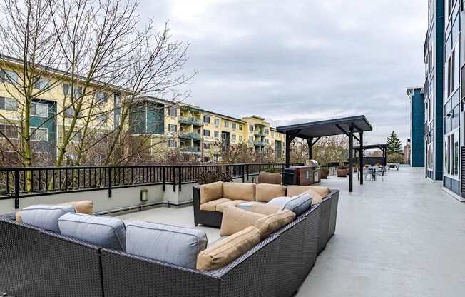 A rooftop patio with a black railing and a white couch.