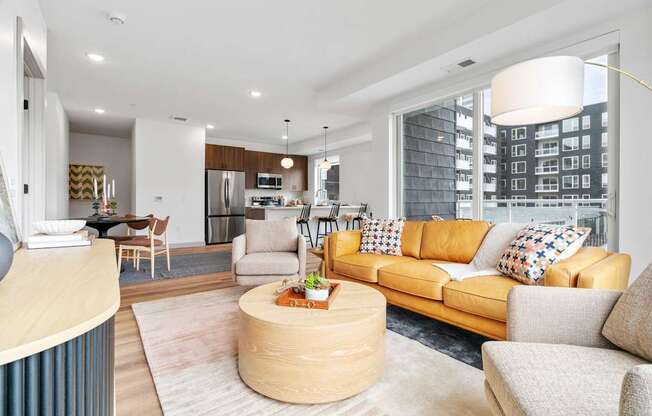 A modern living room with a yellow sofa and a wooden coffee table.