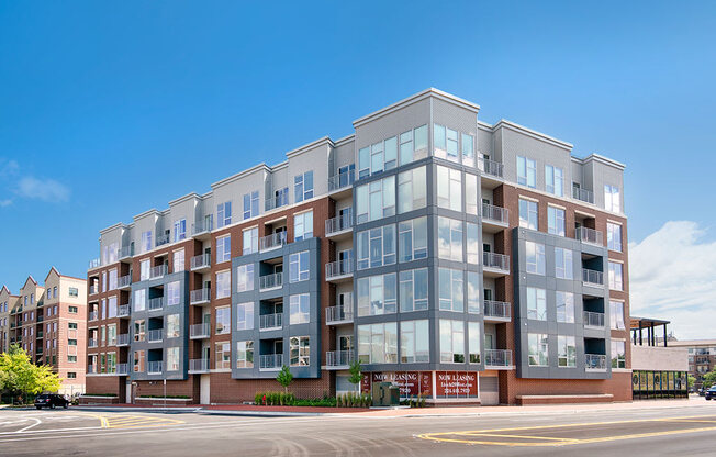 a large apartment building on a street with a blue sky in the background