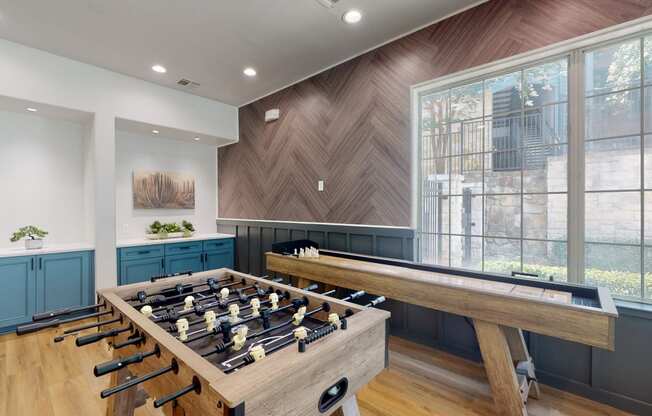 a game room with a foosball table and ping pong table