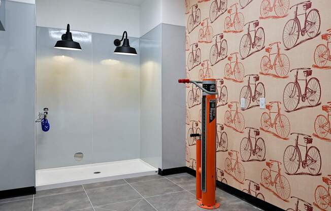 A bathroom with a shower, a towel rack, and a bicycle wallpaper.