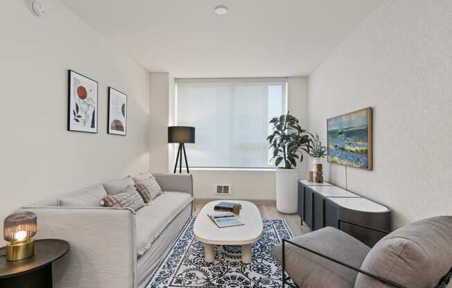 two couches and a coffee table in a living room with a large window