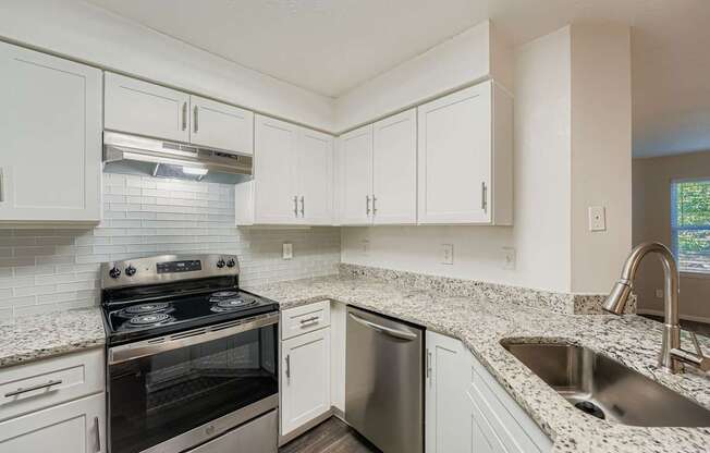 A kitchen with a stove, dishwasher, and sink.