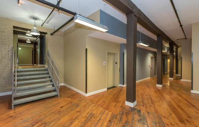 the interior of an empty building with a staircase and wood floors at Mayton Transfer Lofts, Virginia, 23803