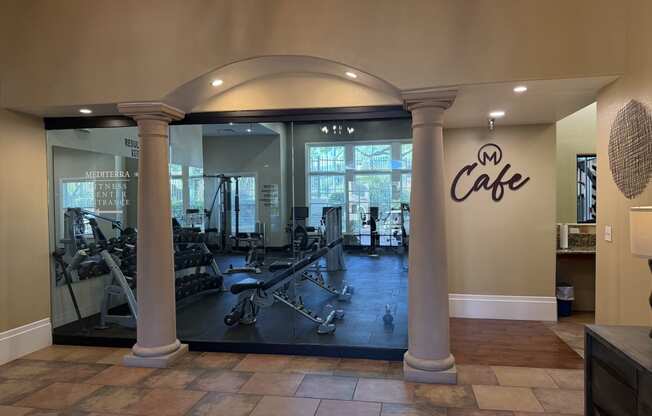 a gym with a glass door with weights and cardio machines