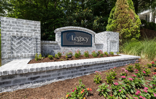 a sign for legacy at the entrance of a garden