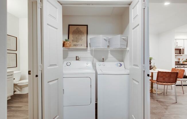 a washer and dryer in a white laundry room at The Olivine, Austin