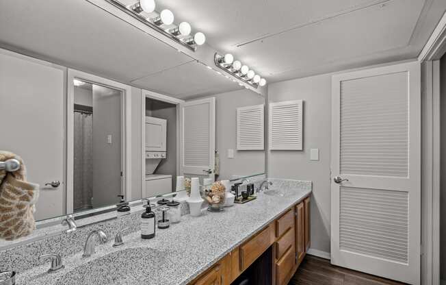 a bathroom with a large mirror and a double sink