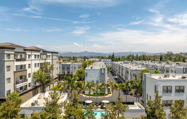 A view of apartment buildings with a pool in the foreground.