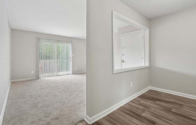 A room with a white door and a window with blinds.