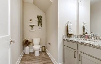 A white toilet sits in a bathroom next to a sink.