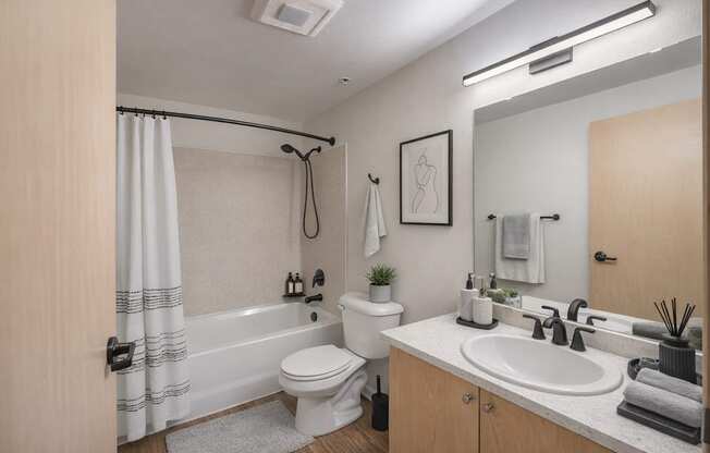 A bathroom with a toilet, sink, and shower.
